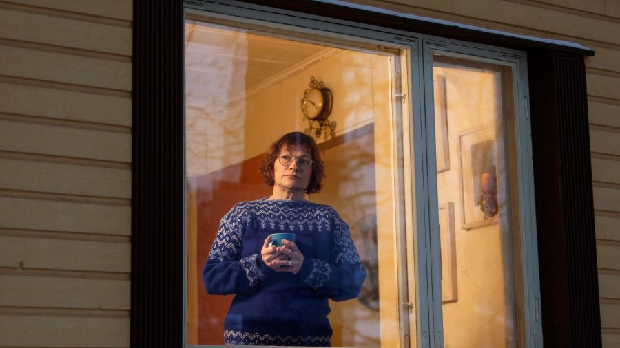 Nainen katsoo ulos ikkunasta.