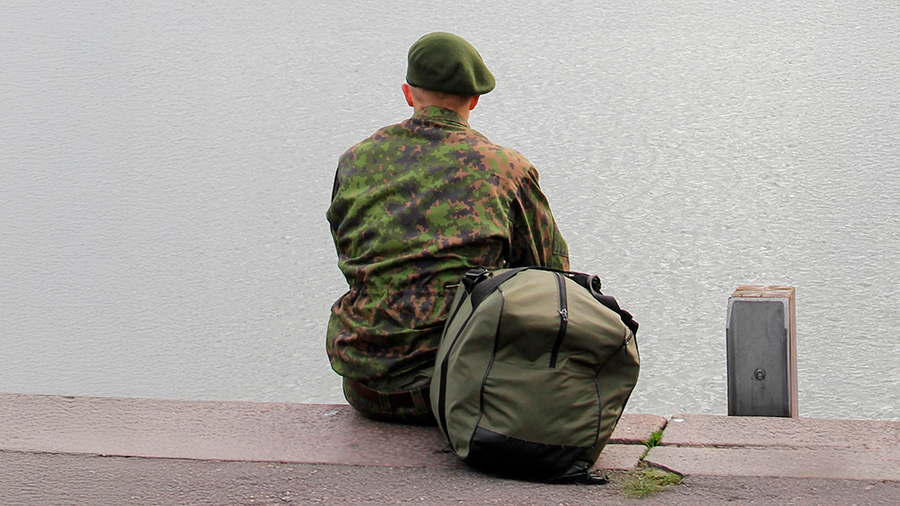 Varusmies istuu rannalla.